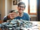College student celebrating with a stack of money.